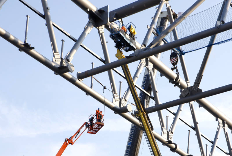 Arbeitsbühnen mit Monteuren innerhalb einer räumlichen Stahlkonstruktion