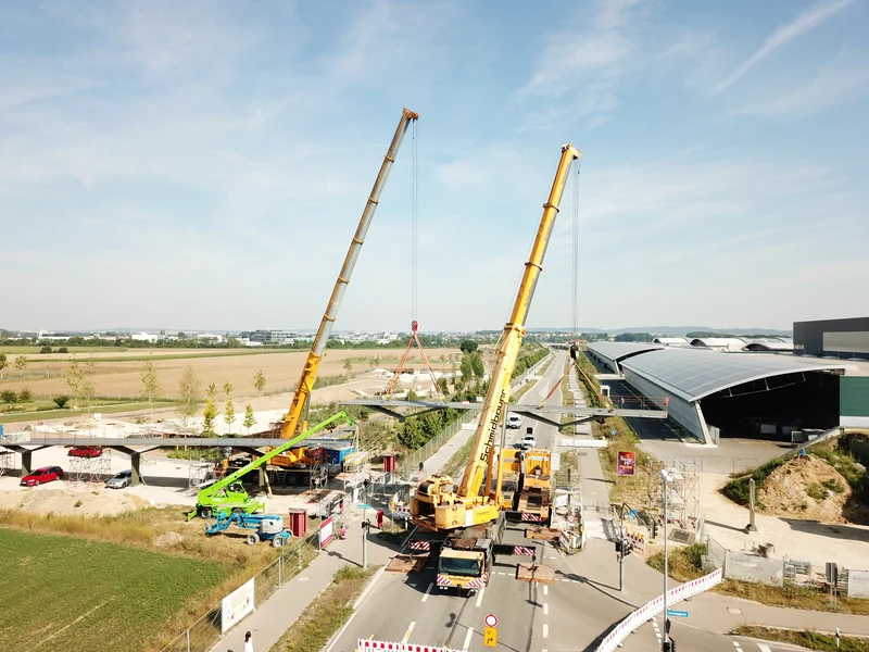 Montage einer Stahlbrücke mit zwei Mobilkranen