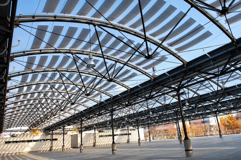 Filigrane Stahlkonstruktion des AWM-Carports mit geschwungenem Dachtragwerk